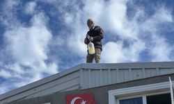 Evini yıktırmamak için çatıya çıktı